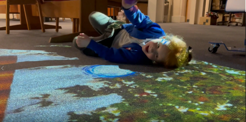 A child enjoying the interactive projection on the floor