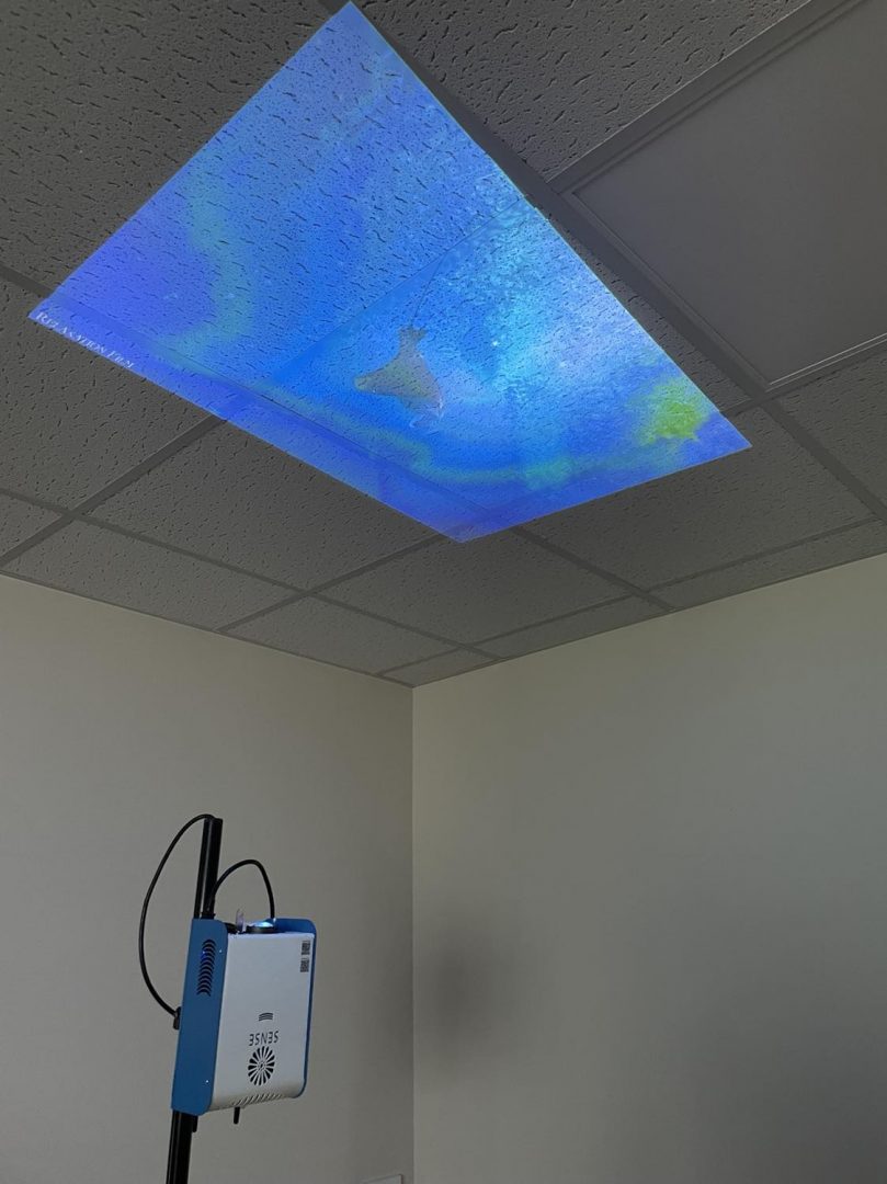 SENse Micro interactive projector being used to project a video of a stingray onto the ceiling for those receiving bed care